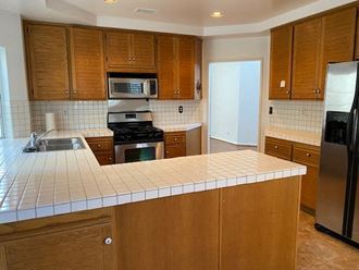 a kitchen with wooden cabinets and a white counter top