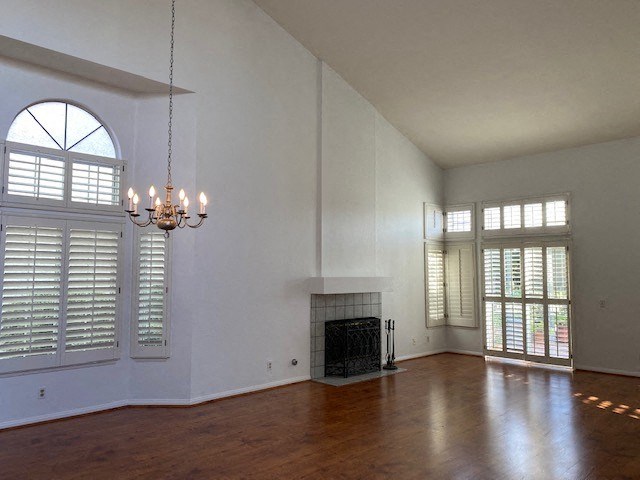 an empty living room with a fireplace and a chandelier