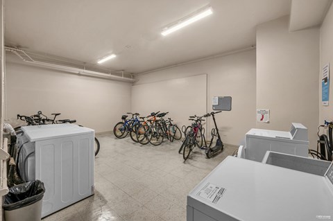 A room with a white wall and a white floor with a white ceiling and a white trash can.