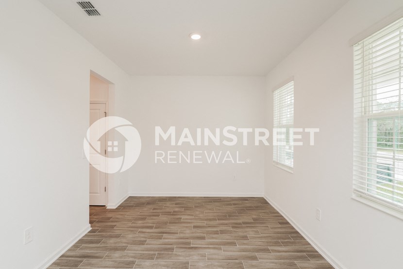 a renovated living room with wood floors and white walls