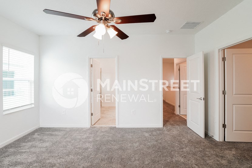 a bedroom with a ceiling fan and a closet