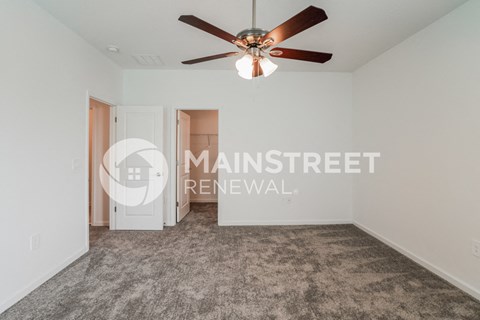 a renovated living room with carpet and a ceiling fan