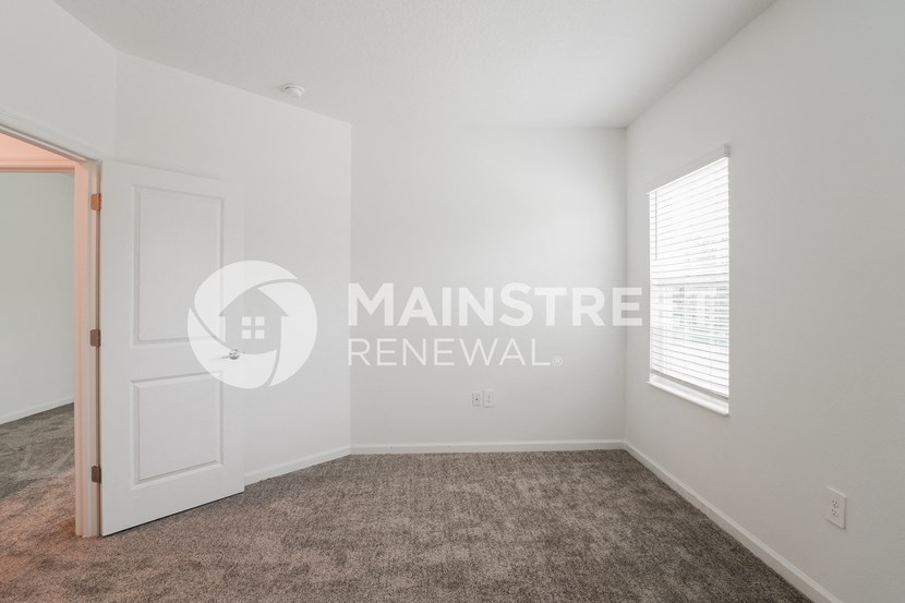 a room with a carpeted floor and a white door