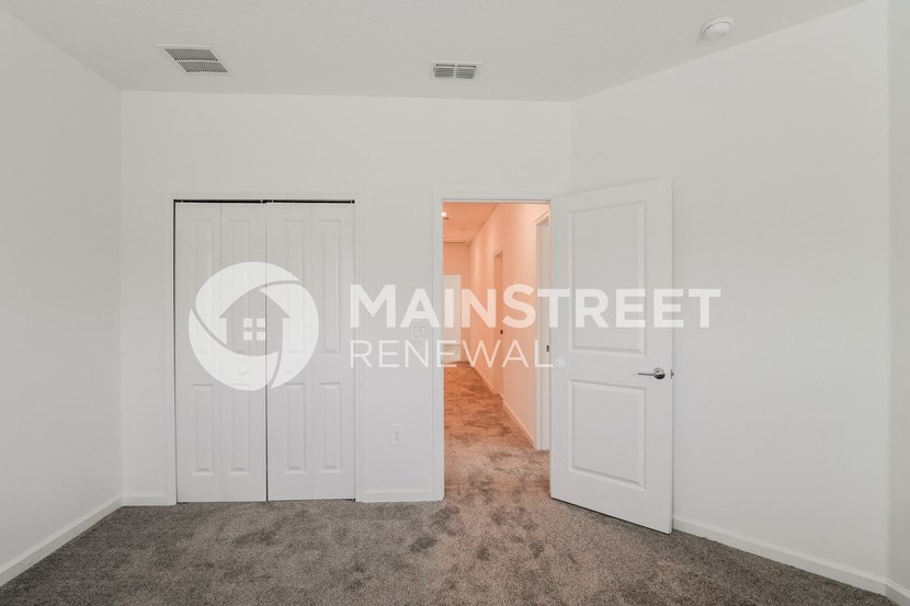 a bedroom apartment with a closet and a door to a hallway