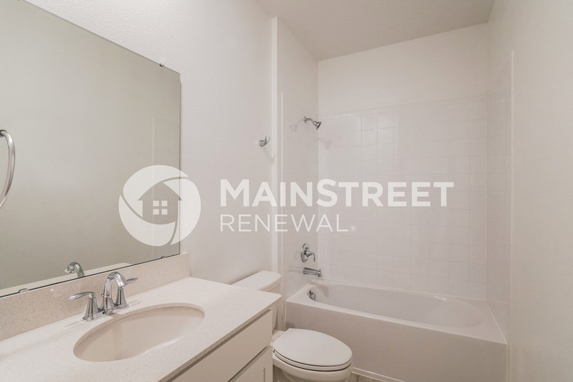 a small bathroom with a tub and a sink and a mirror