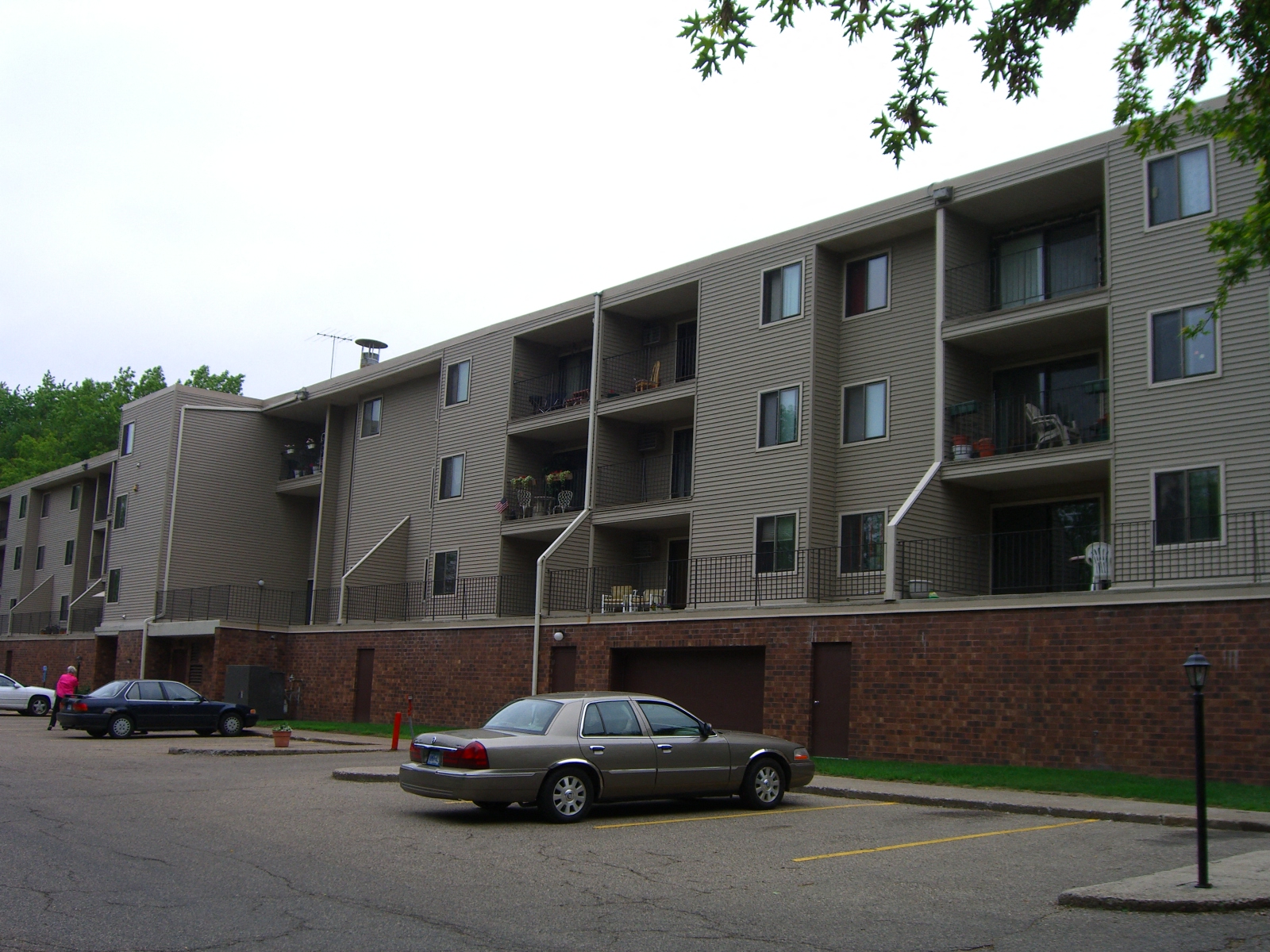 an apartment building with cars parked in a parking lot