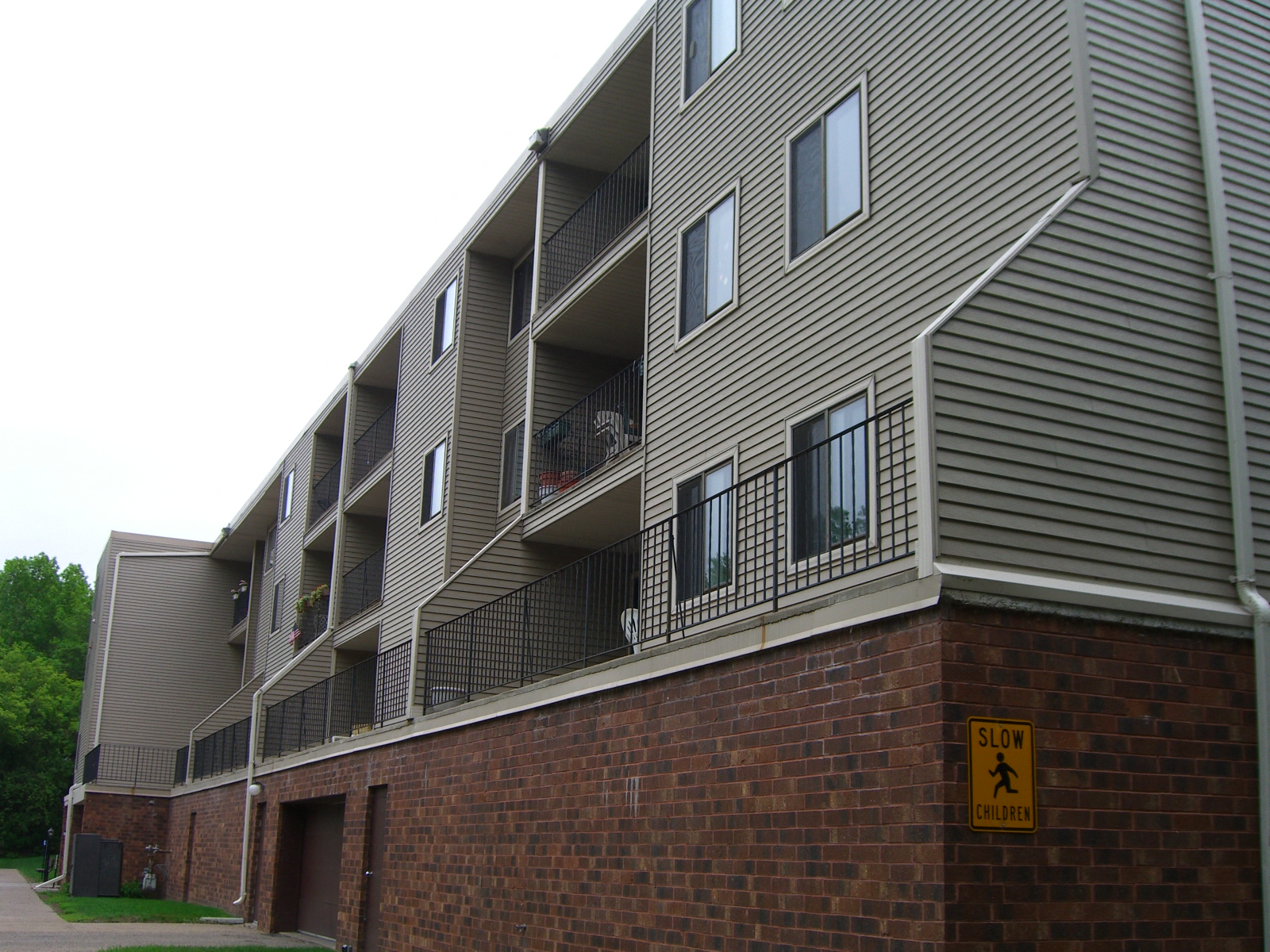 the exterior of an apartment building with a street sign