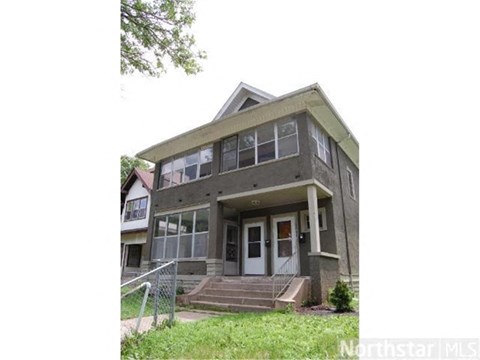 A two-story house with a front porch and a garage door.