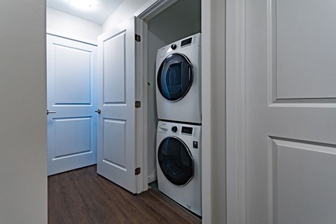 A washing machine is in a small space between two doors.