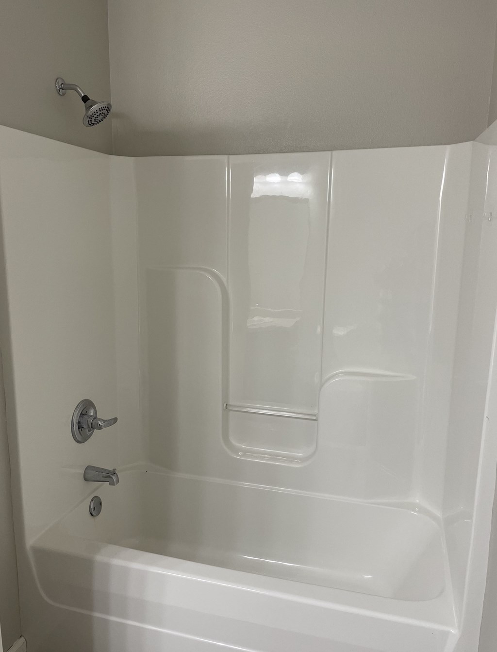 a white tub with a shower in a bathroom