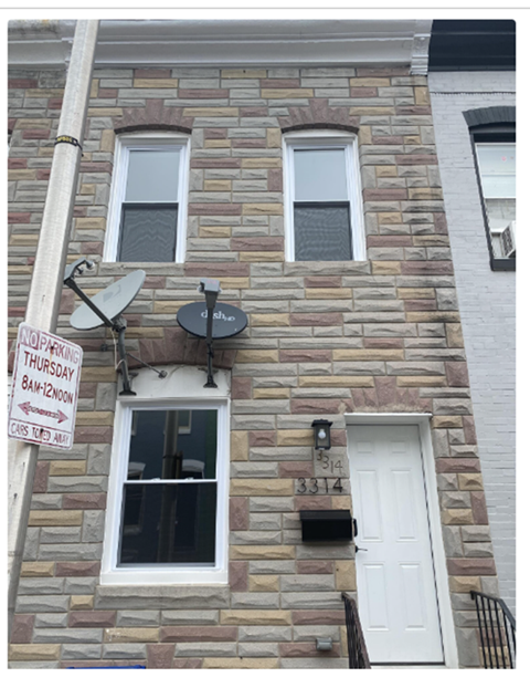 the front of a brick building with a street sign