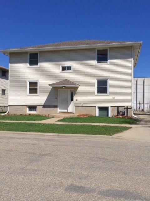 A two-story house with a garage door on the first floor.