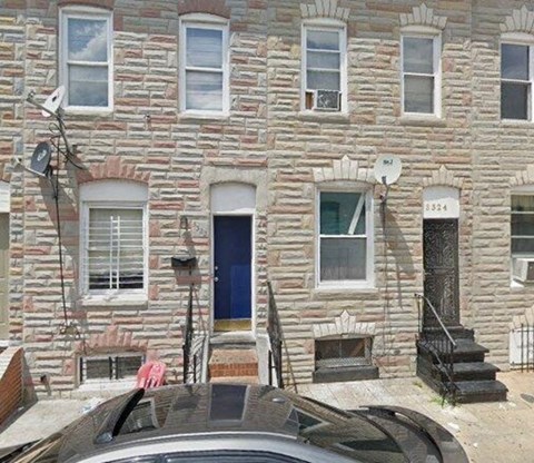 a brick house with a car parked in front of it