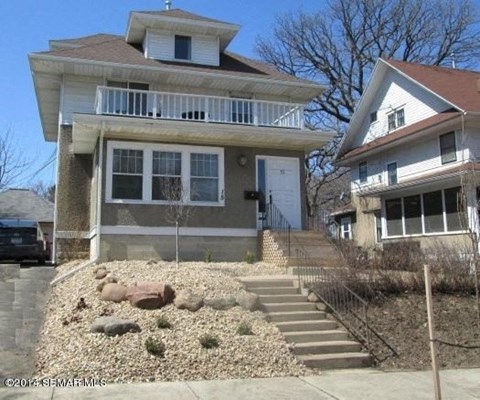 a house with stairs and a yard with rocks