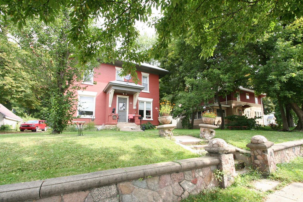 a red house with a stone fence in front of it