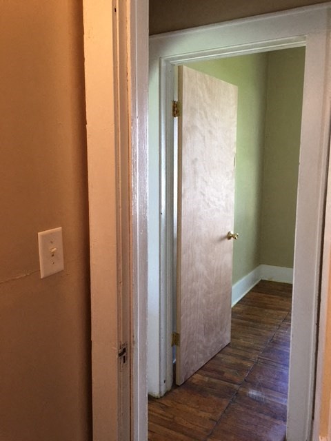 a hallway with a door to a room with a tile floor