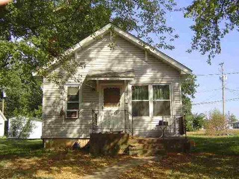 an old house with a tree in front of it
