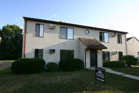 a white house with a black sale sign in front of it