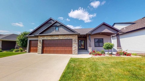 A house with a brown garage door and a stone pillar.