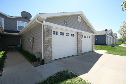 a white garage door in front of a gray house