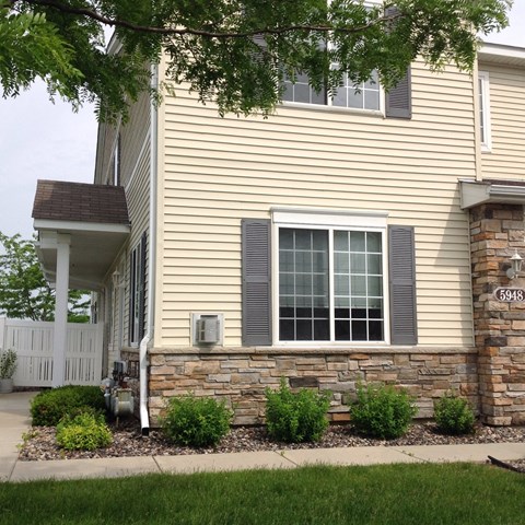 A house numbered 5948 with a white fence and a window with grey shutters.