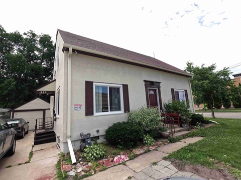 A small house with a red door and a window with a white frame.