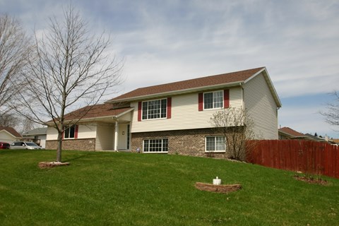 A house with a brown roof and a white fence.