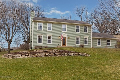 a green house on top of a green hill