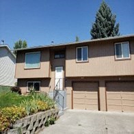 a house with two garage doors and a driveway in front of it