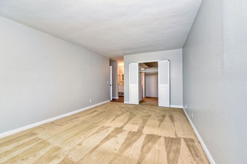 a spacious living room with wood flooring and white walls