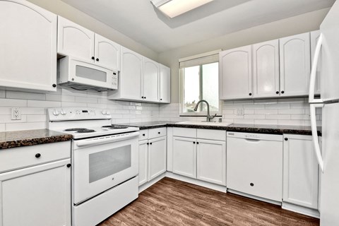 a white kitchen with white appliances and white cabinets