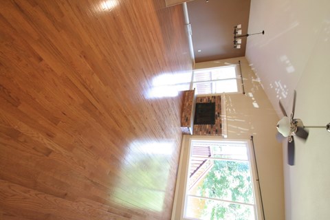 A room with wooden floors and a ceiling fan.
