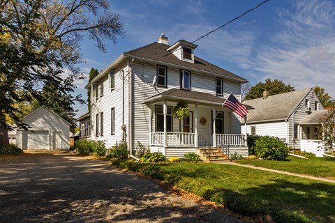 a white house with an flag on the porch
