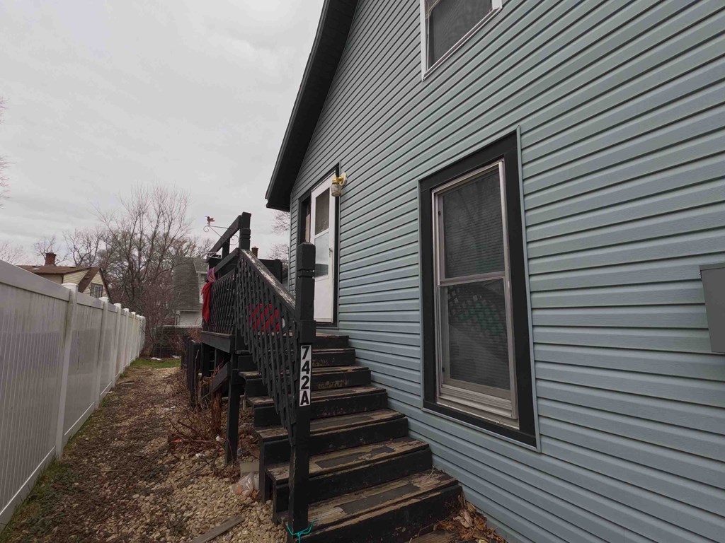 A house with a blue siding and a black railing.