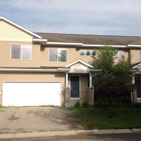 A house with a white garage door and a brown roof.