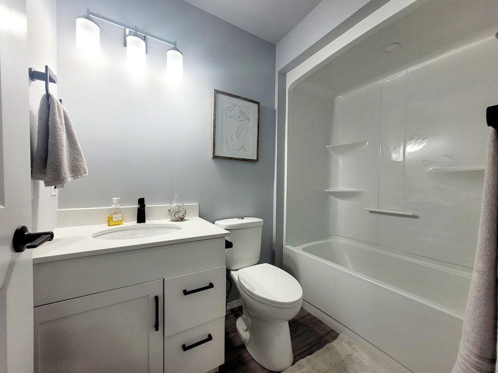 A white bathroom with a toilet, sink, and bathtub.