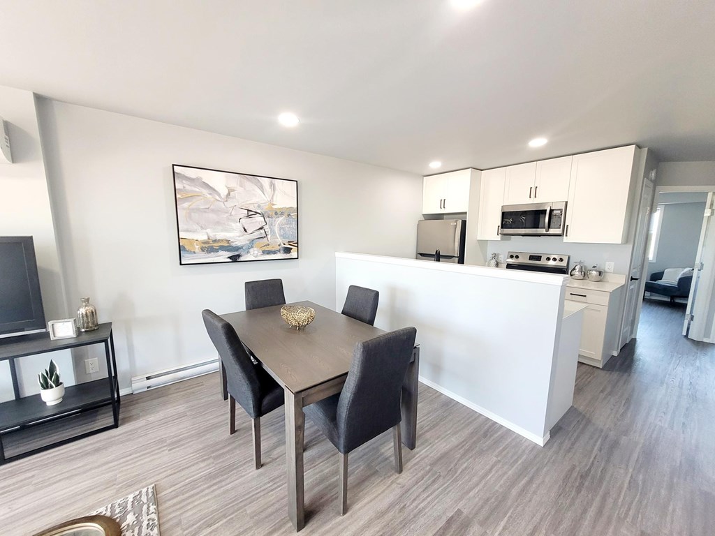 A dining room with a table and chairs.