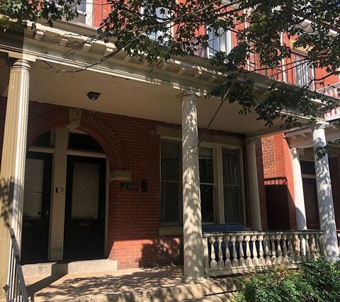 a brick house with a porch and a door