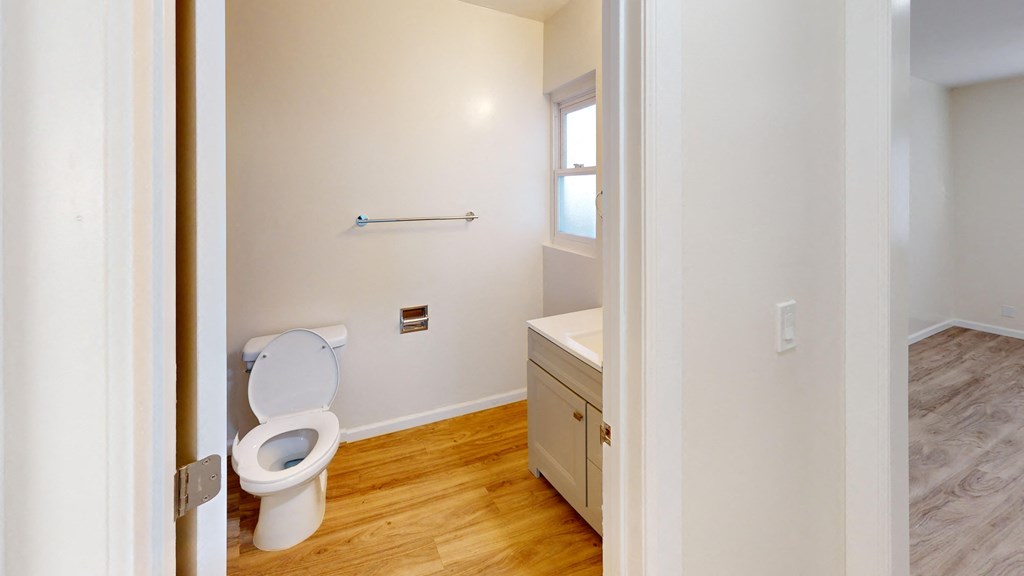 a bathroom with a toilet and a sink and a window
