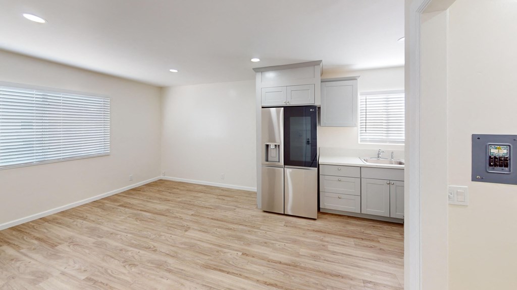 an empty kitchen with a refrigerator and a sink