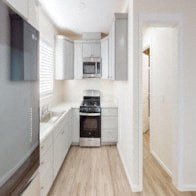 a white kitchen with white cabinets and a black stove