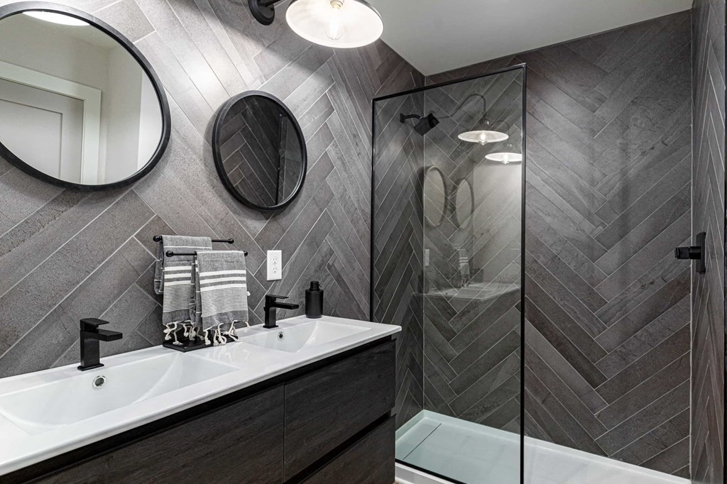 a bathroom with a sink and a shower and a mirror