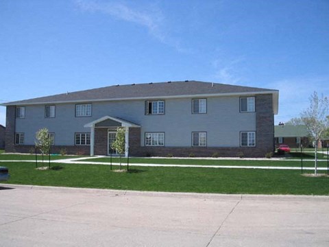 a large white house with a driveway and grass