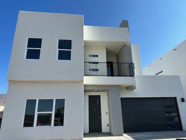 a white house with a balcony and a black door