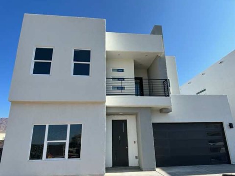 a white house with a balcony and a black door