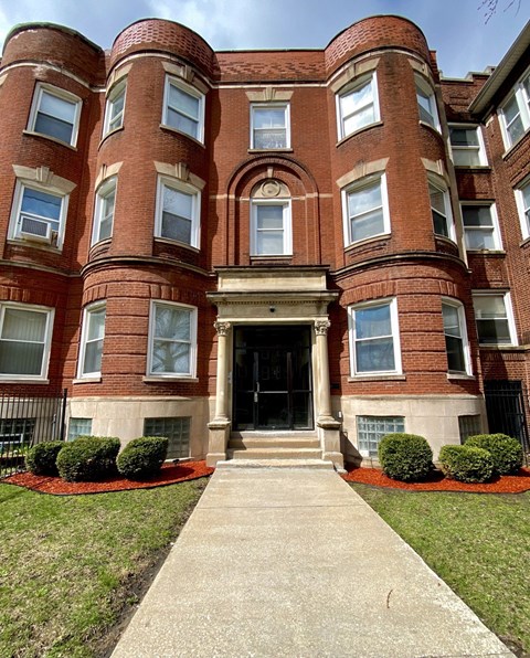 A red brick building with a black door and windows.