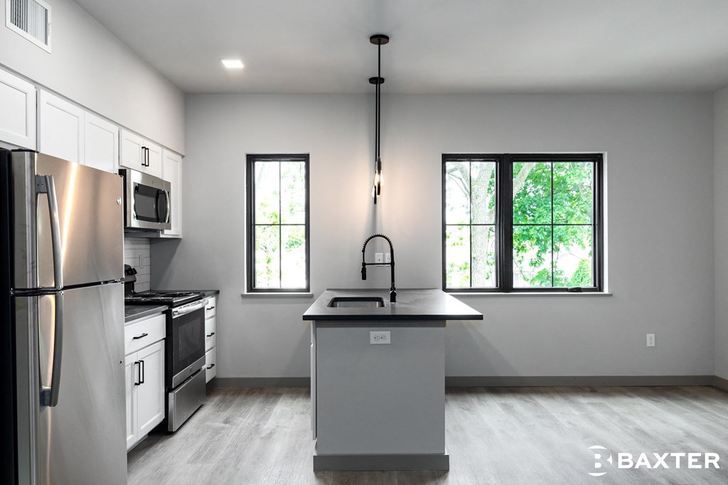an empty kitchen with stainless steel appliances and a counter top