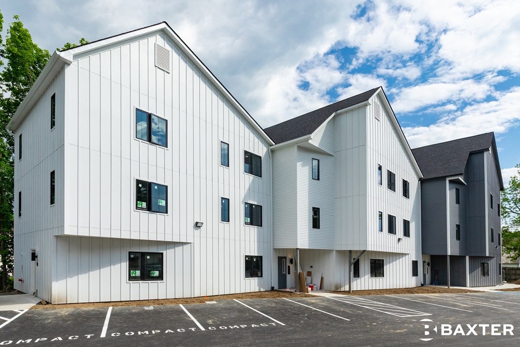 a large white building with a parking lot