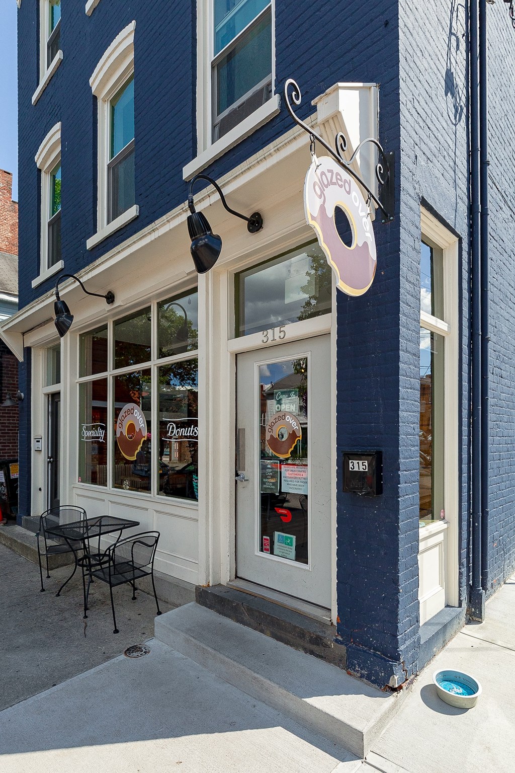 a blue building with a pink donut sign on the side of it