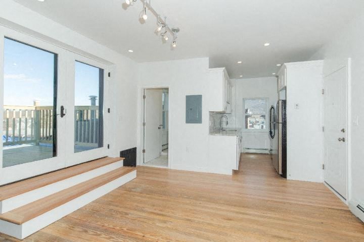 an empty living room with white walls and wood floors
